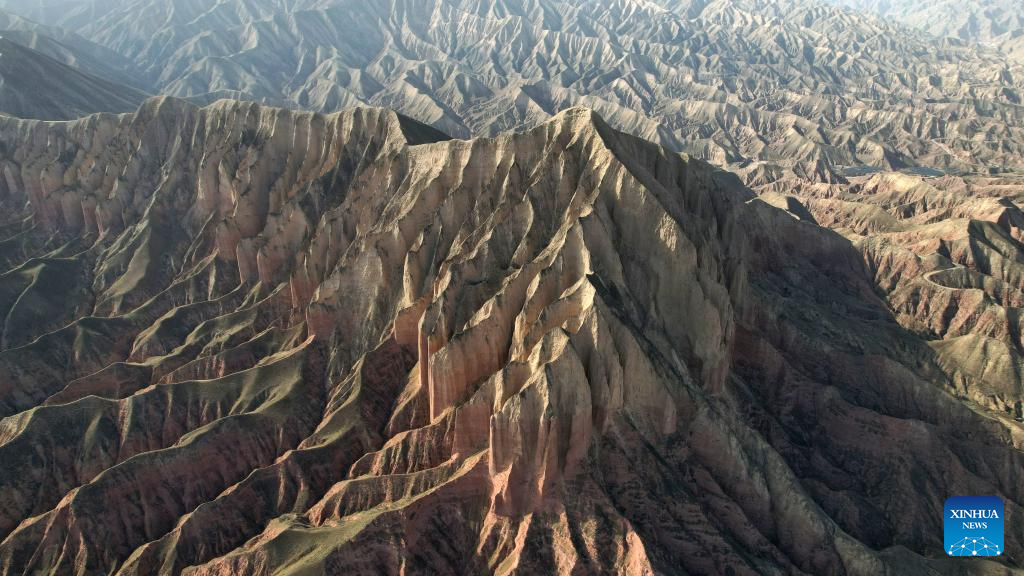 This aerial drone photo taken on April 4, 2026 shows a view of the Shilaquan Canyon in Tangwang Town of Dongxiang Autonomous County, Linxia Hui Autonomous Prefecture, northwest China's Gansu Province. Shilaquan Canyon has an average elevation of approximately 2,000 meters. The red sandstone and gravel layers on both sides of the canyon have been shaped by water erosion and wind abrasion, forming a distinctive Danxia landform. (Xinhua/Chen Bin)