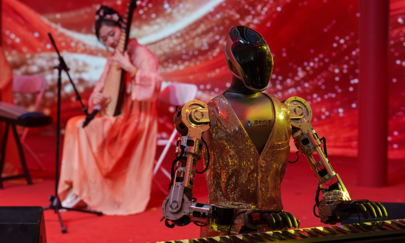 A robot accompanies a traditional music performance on stage at a Spring Festival tech temple fair in Beijing, on February 19, 2026. Photo: VCG