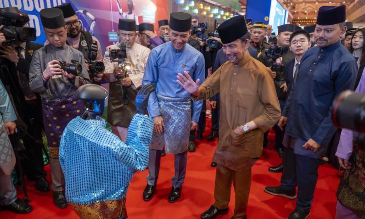 Brunei's Sultan Haji Hassanal Bolkiah Mu'izzaddin Waddaulah (2nd R) interacts with a humanoid robot from China at Brunei's traditional Hari Raya celebration in Bandar Seri Begawan, Brunei, on April 4, 2026. (Information Department of Brunei's Prime Minister's Office/Handout via Xinhua)