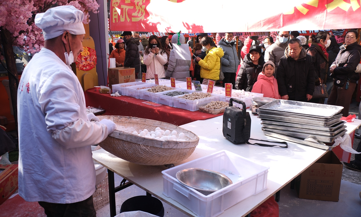Tourists watch the live handmade preparation of traditional yuanxiao at a fair on February 19, 2026, in Shenyang, Northeast China's Liaoning Province. Photo: VCG
