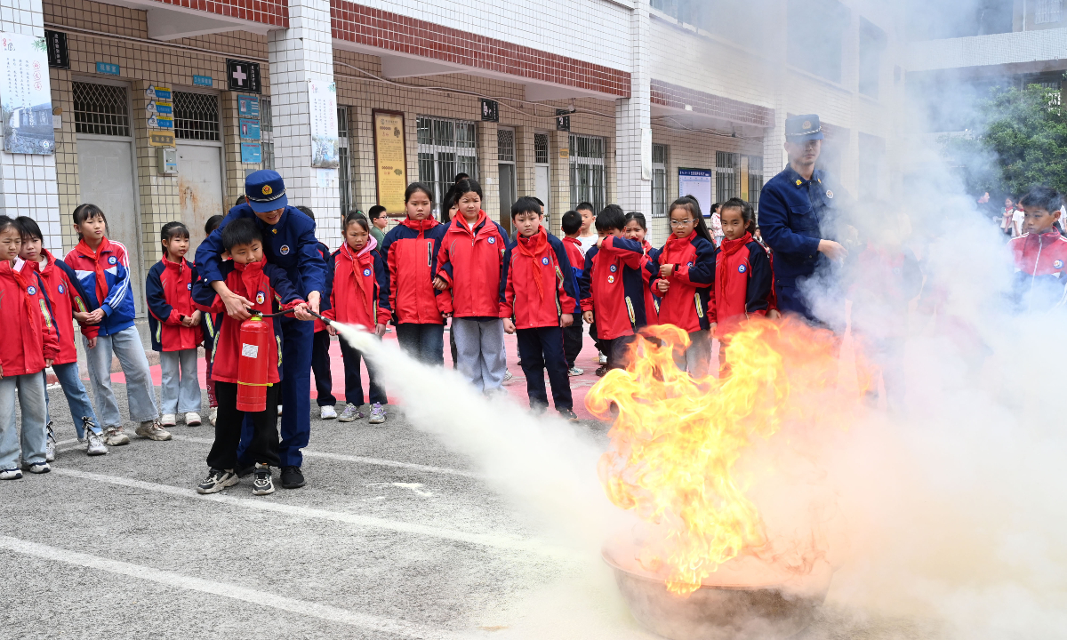 Firefighters from Neijiang, Southwest China’s Sichuan Province, demonstrate firefighting skills to students at a local school on March 30, 2026. Photo: IC