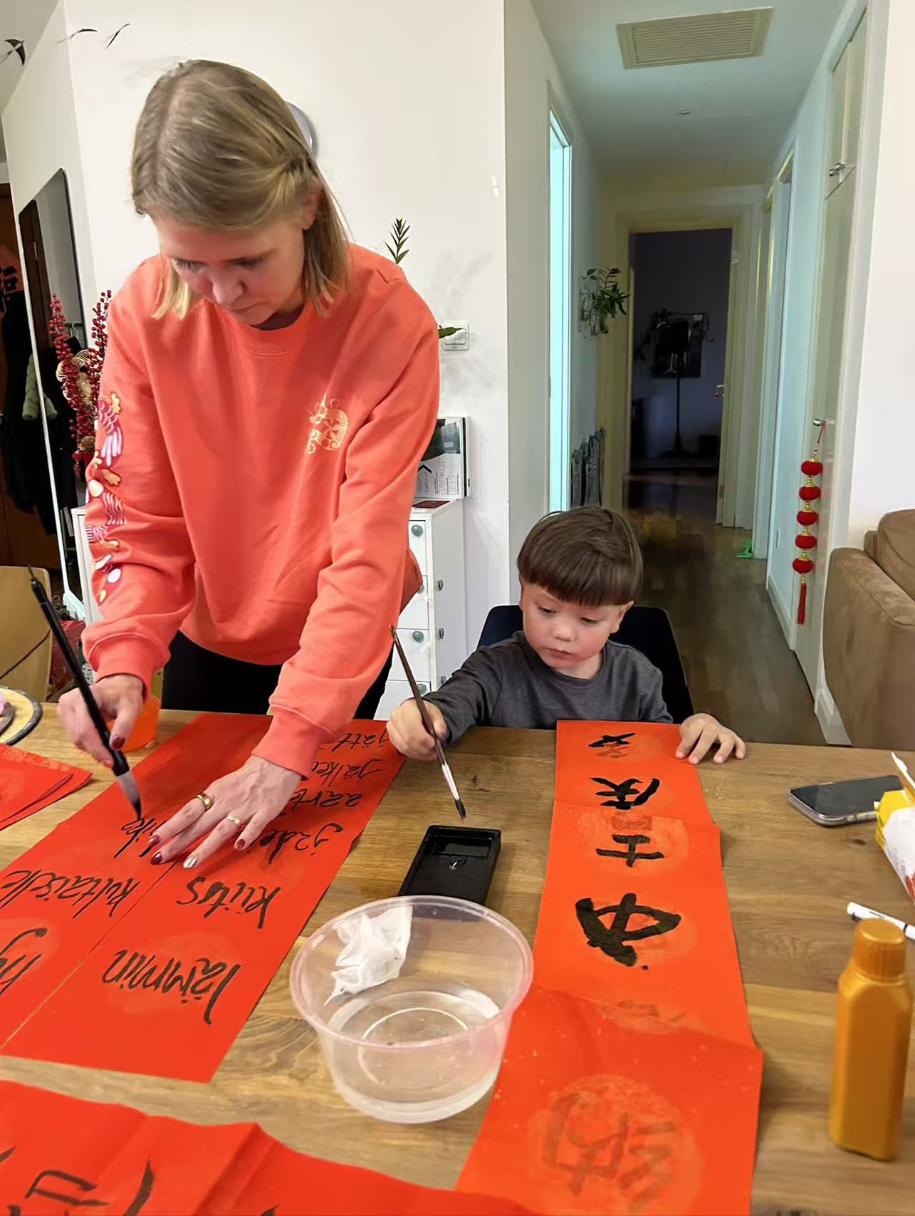 Janna Laine (left) and her son write Spring Festival couplets in Beijing. Photo: Courtesy of Janna Laine