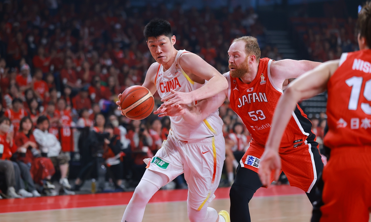 China's center Hu Jinqiu dribbles with the ball against Japan's Alex Kirk during the FIBA World Cup Asian qualifier on February 26, 2026 in Okinawa. Photo: VCG