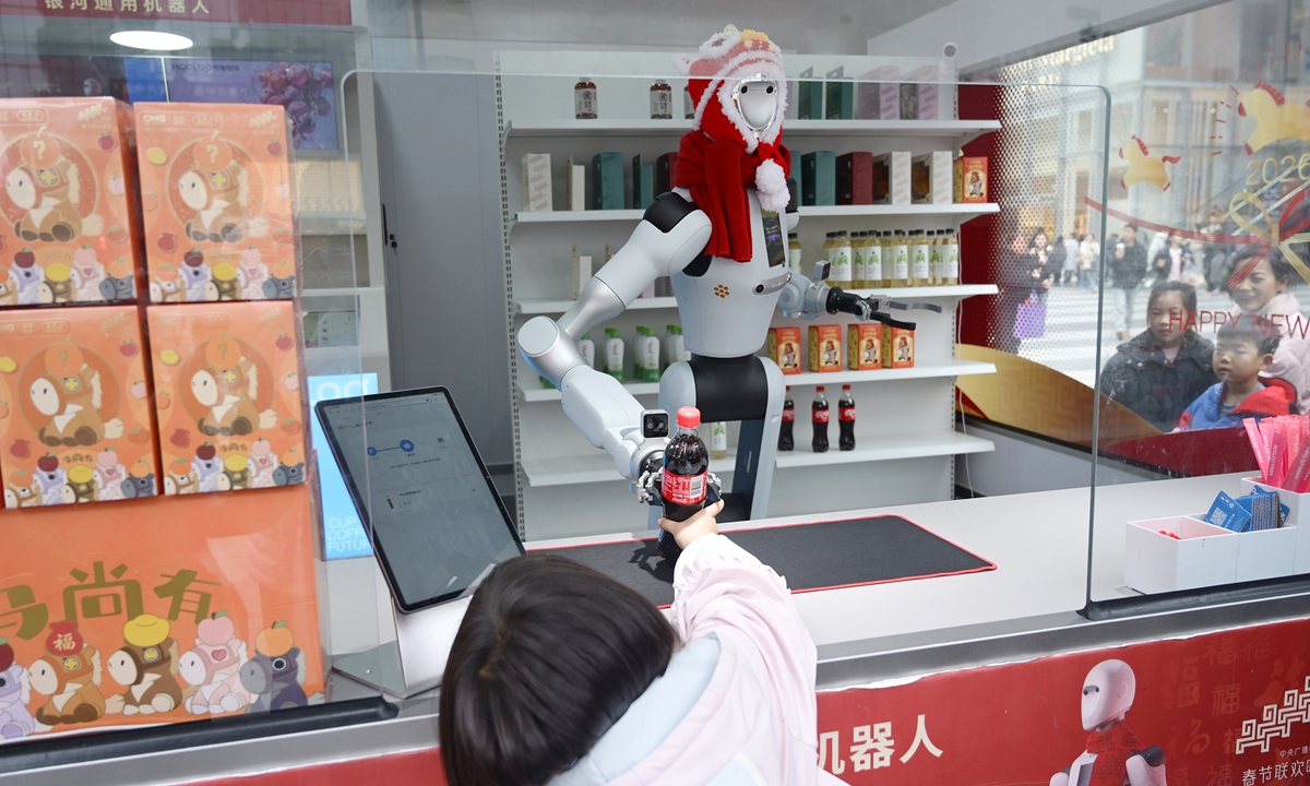 A robotic vendor hands a beverage to a customer on a street in Changsha, Central China's Hunan Province on February 25, 2026. Photos on this page: VCG