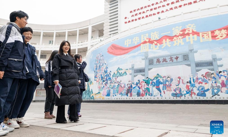 Zhang Qiongli (2nd R) and students walk at Enshi Tujia and Miao Autonomous Prefecture Senior High School in Enshi, central China's Hubei Province, Feb. 4, 2026. Zhang Qiongli, a deputy to the National People's Congress (NPC) and a political teacher at Enshi Tujia and Miao Autonomous Prefecture Senior High School, has been dedicated to frontline education for sixteen years.
During her tenure, Zhang has put forward multiple proposals centered on students' needs, earning wide recognition. In 2023, she recommended promoting desks and chairs tailored to the reclined rest requirements of primary and secondary school students, with related measures gradually implemented in various regions. In 2024, she proposed establishing rural libraries and optimizing the academic proficiency examination for general senior high schools. In 2025, focusing on research in red education, she advocated for formulating unified curriculum standards, advancing digital upgrades, and enhancing the educational function of red resources.
As for the 2026 NPC session, Zhang continues to concentrate on the education sector, proposing the integration of science popularization education with ideological and political education to strengthen value guidance, and purify the online environment for youth.
As a representative of the Tujia ethnic group, she also plans to propose measures to reinforce the consciousness of the Chinese national community based on the realities of Enshi. Zhang Qiongli stated, As an NPC deputy, it is unnecessary to achieve monumental feats; instead, one should treat the small matters surrounding the people as major concerns. Only by rooting oneself in the grassroots can one hear the most genuine voices and respond promptly. Photo: Xinhua