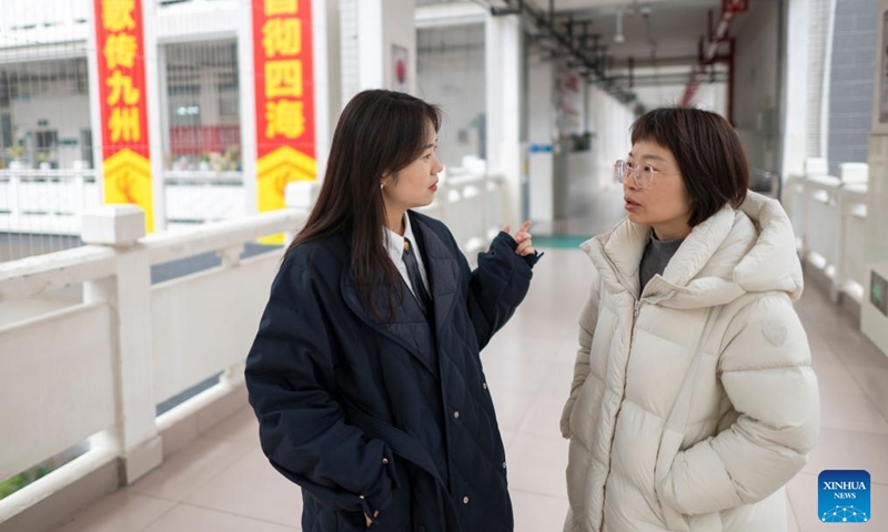 Zhang Qiongli talks with a colleague at Enshi Tujia and Miao Autonomous Prefecture Senior High School in Enshi, central China's Hubei Province, Feb. 3, 2026. Photo: Xinhua