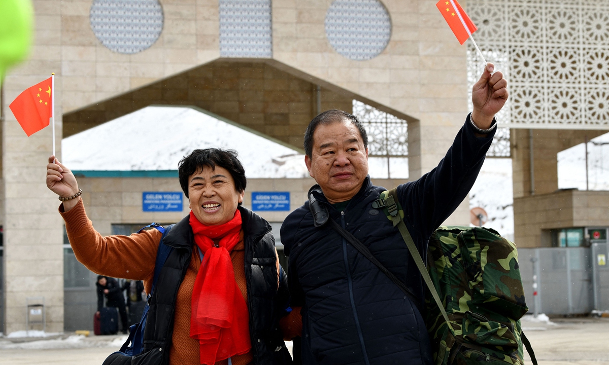 Chinese nationals wave their national flags as they arrive in northeastern Turkey after passing through the Razi-Kapikoy border crossing with Iran in Van, on March 2, 2026. Photo: VCG