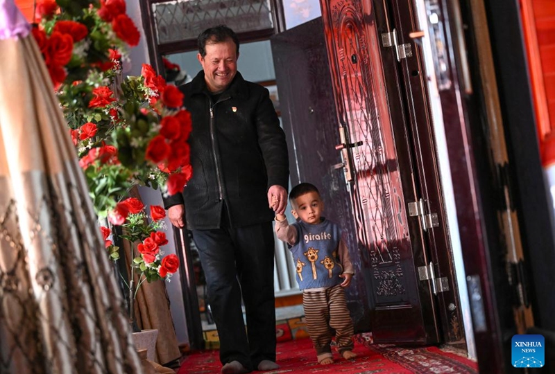 Musajan Khairat holds hand of a child at his home in Keregetas Village, Xinyuan County of Ili Kazak Autonomous Prefecture, northwest China's Xinjiang Uygur Autonomous Region, Feb. 9, 2026. Photo: Xinhua