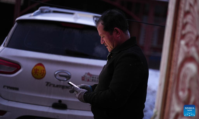 Musajan Khairat checks messages from villagers asking for help with welding in the yard of his home in Xinyuan County of Ili Kazak Autonomous Prefecture, northwest China's Xinjiang Uygur Autonomous Region, Feb. 9, 2026. Photo: Xinhua