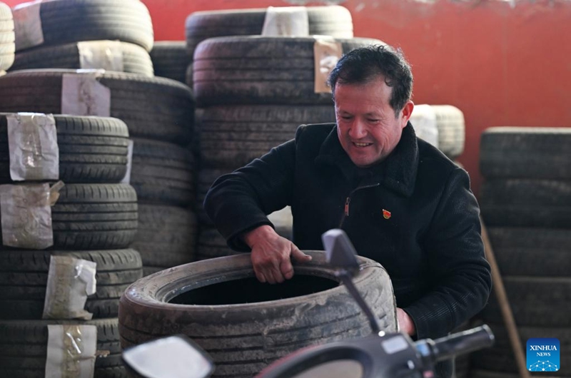 Musajan Khairat carries a tire at his workshop in Keregetas Village, Xinyuan County of Ili Kazak Autonomous Prefecture, northwest China's Xinjiang Uygur Autonomous Region, Feb. 9, 2026. Musajan provides tires storage services for local villagers for free every winter. Photo: Xinhua