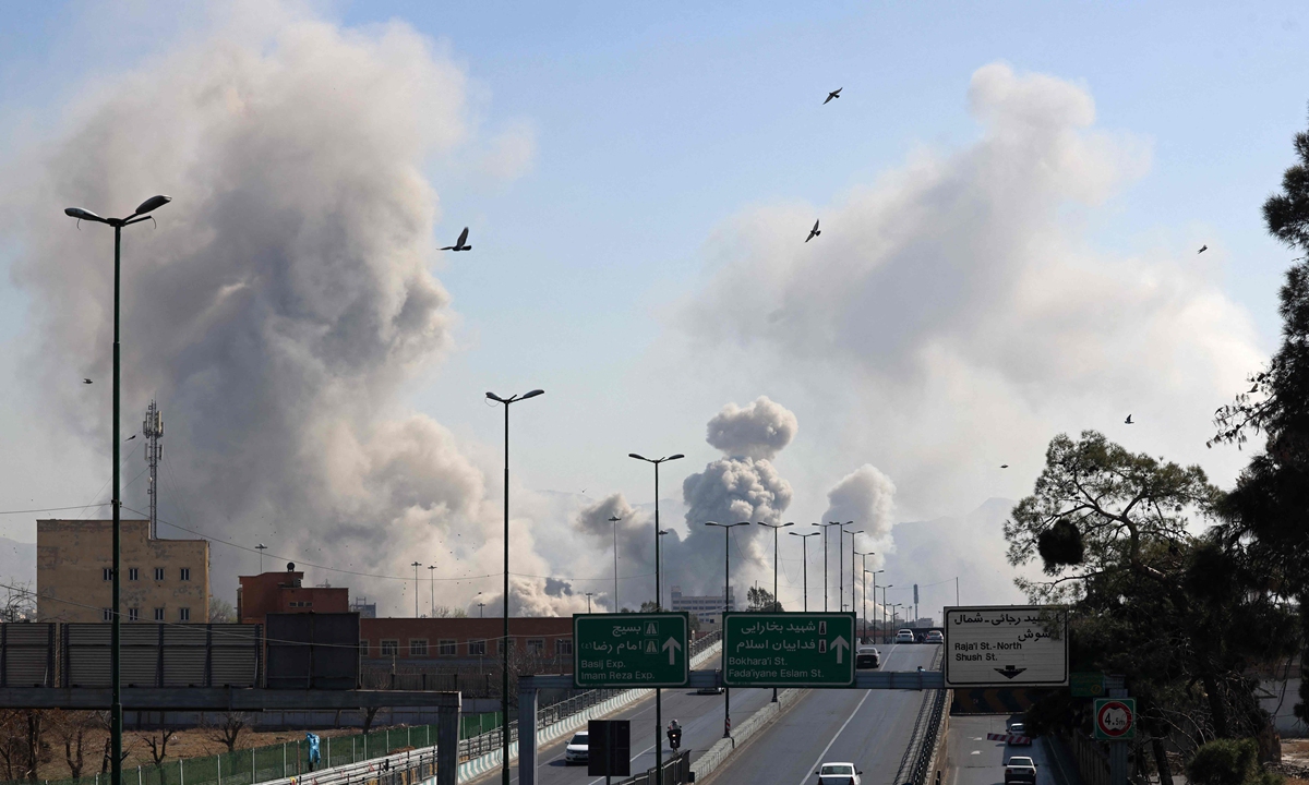 Vehicles drive along an expressway against the backdrop of smoke rising after a strike on the Iranian capital of Tehran on March 5, 2026. Photo: VCG