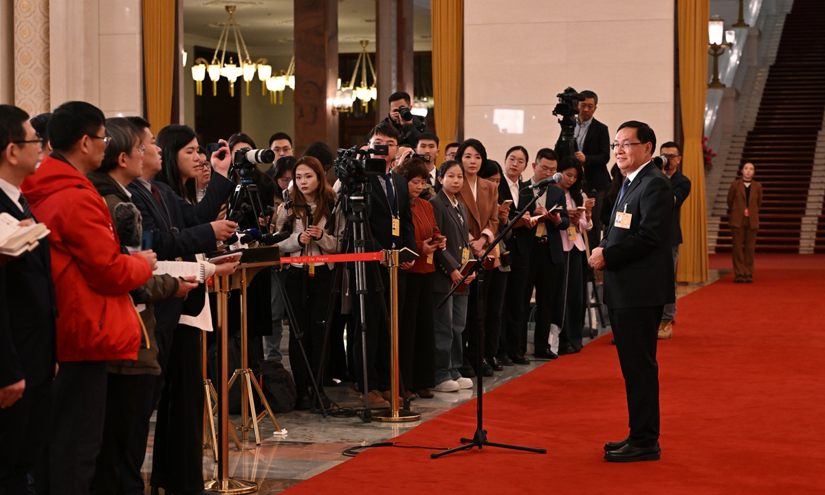 Zhang Yuzhuo, chairman of the State-owned Assets Supervision and Administration Commission of the State Council, speaks with journalists at the Ministers' Corridor of the fourth session of the 14th National People's Congress, China's top legislature, at the Great Hall of the People in Beijing on March 5, 2026.  
Photo: VCG