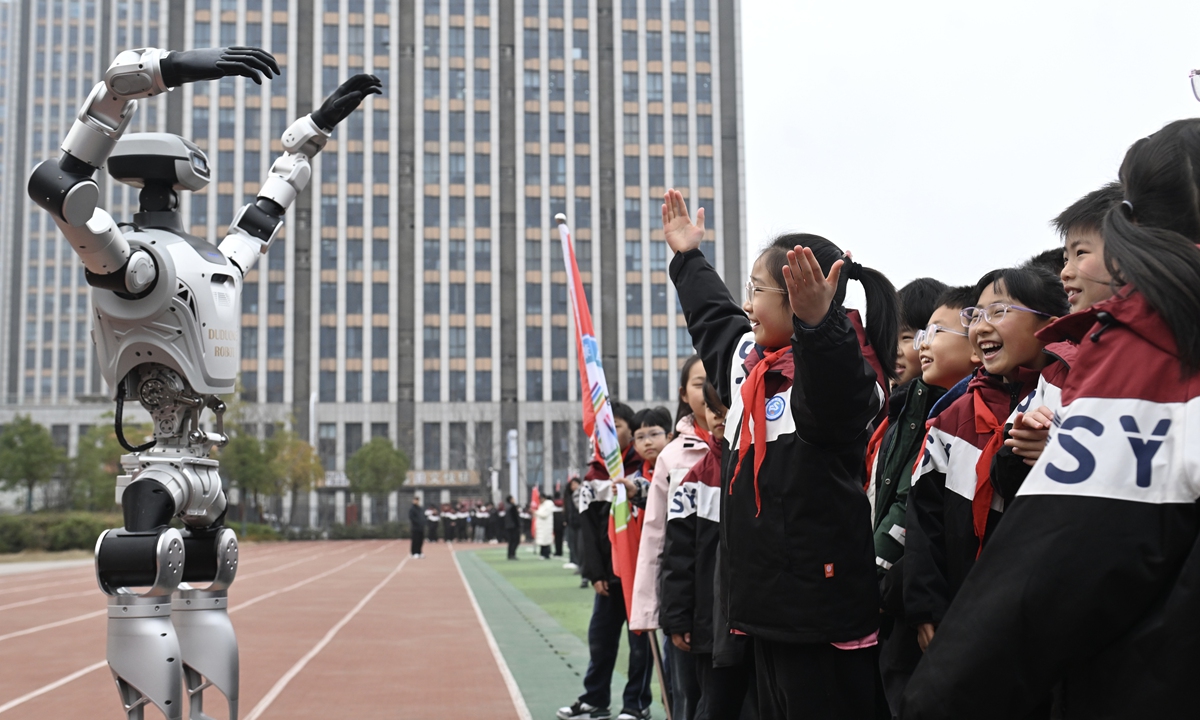 A student from a junior high school in Hefei, East China's Anhui Province, interacts with a robot teacher at the school's opening ceremony on March 5, 2026. Photo: VCG