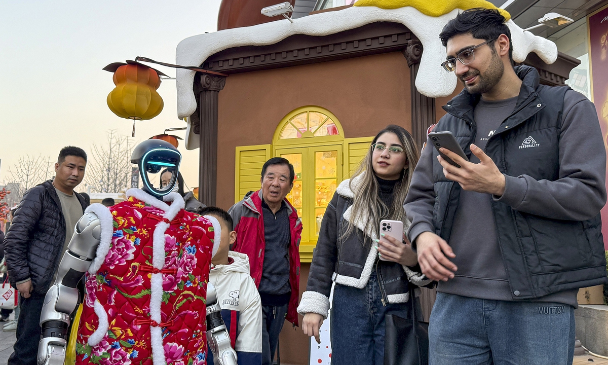 Visitors watch a humanoid robot on the street in Zhengzhou, Central China's Henan Province, on February 14, 2026. Photo: VCG