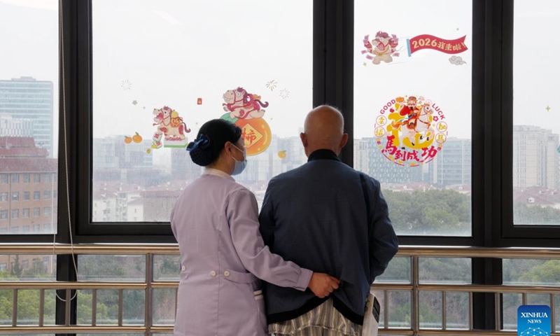 A nursing assistant helps an inpatient walk at a hospital in Shanghai, east China, Feb. 26, 2026.(Xinhua/Liu Ying)