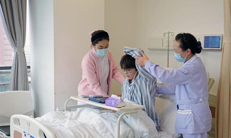 A nurse (L) and nursing assistant (R) help an inpatient with post-surgery rehabilitation exercises at a hospital in Shanghai, east China, Feb. 26, 2026. China's hospitals are piloting companion-free care services to ease the heavy burden of daily care-giving on the inpatients' families.

The new mode of operation requires hosting hospitals to directly employ trained nursing assistants to provide 24-hour non-medical care for inpatients with particular needs.

Such services used to rely solely on family members of the inpatients or private caregivers they hire.(Xinhua/Liu Ying)