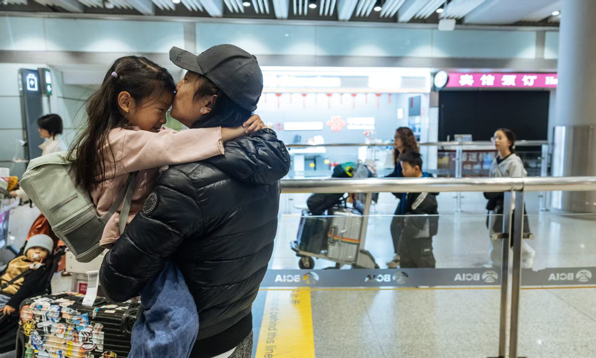 A father scoops up his young daughter and kisses at her forehead lightly after the girl, among other Chinese nationals stranded in Middle East, arrived safely in Beijing on March 9, 2026 after taking a flight from Dubai. Photo: Li Hao/GT
