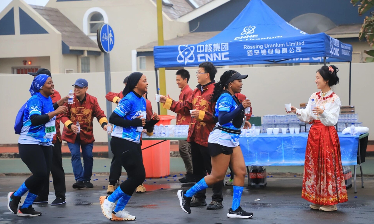 Staff members at a refreshment station set up by the Chinese side provide drinks to passing runners sat the 35th Rossing National Marathon. Photo: Screenshot from the CNNC Wechat account