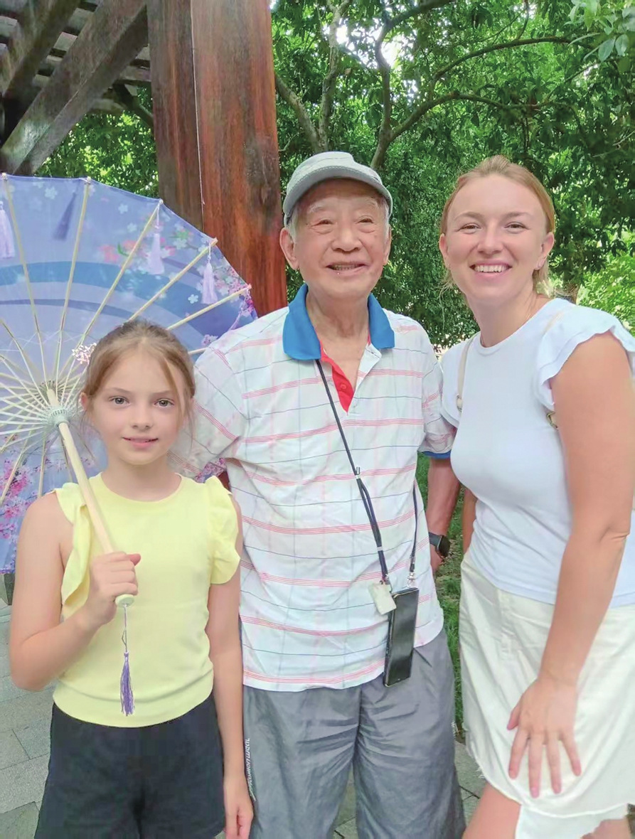 Zhou Panlin (center) poses with Russian tourists after chatting with them in English in Hangzhou, East China's Zhejiang Province. Photo: Courtesy of Zhou