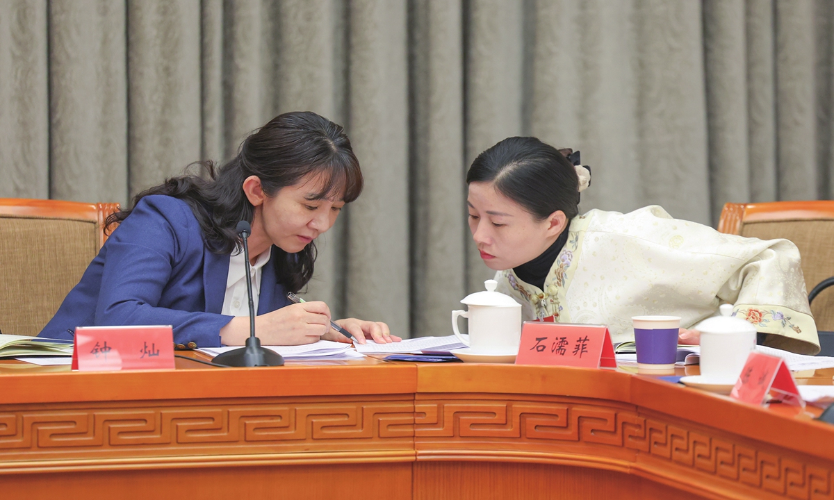 Shi Rufei (right) and Zhong Can, both deputies to the National People's Congress (NPC), exchange ideas during a group discussion of the Guangxi delegation at the fourth session of the 14th NPC in Beijing, on March 10, 2026. Photo: VCG