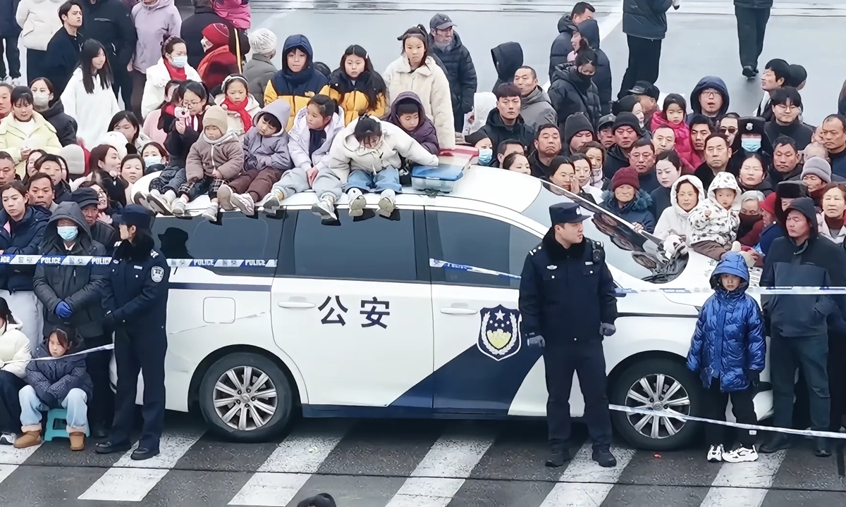 A viral video shows children sitting atop a police car and enjoying a street show while police officers stand beside them to protect them in Tangyin County, Anyang, Central China's Henan Province, on March 4, 2026. Photo: Screenshot of the video