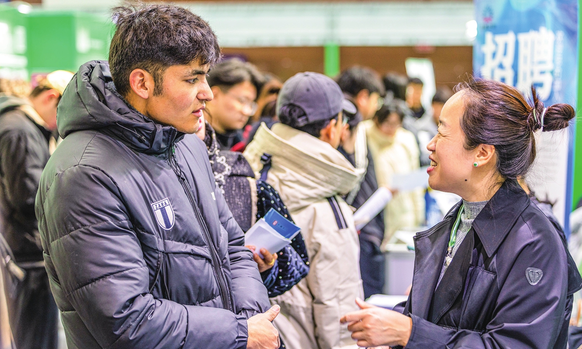 A job seeker (left) inquires about recruitment at the 2026 spring job fair for college graduates in Urumqi, capital of Northwest China's Xinjiang Uygur Autonomous Region on March 13, 2026. Official data show the number of college graduates in China is expected to reach 12.7 million in 2026. Photo: VCG