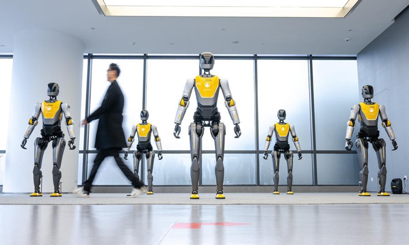 A visitor walks past robots displayed at a humanoid robot innovation center in Wuhan East Lake High-tech Development Zone, also known as the optics valley of China, in Wuhan, central China's Hubei Province, Dec. 4, 2025. (Xinhua/Xiao Yijiu)