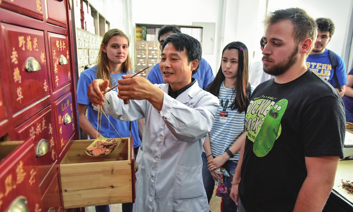 A herbalist teaches foreign students how to identify Chinese medicinal herbs at a TCM hospital in Qingdao, East China's Shandong Province. Photo: VCG