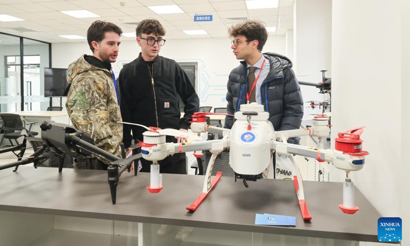 Students from Italy's Jobs Academy Foundation look at a drone displayed at Tianjin Modern Vocational Technology College in north China's Tianjin Municipality, March 16, 2026. (Tianjin Modern Vocational Technology College/Handout via Xinhua)

