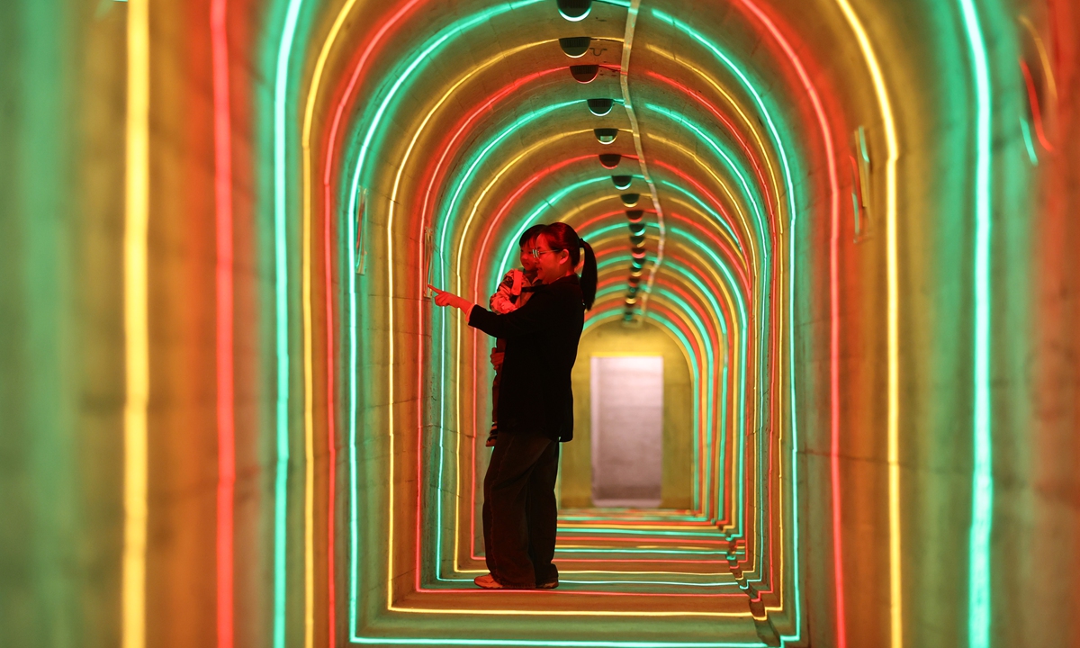 A woman and a child explore an exhibition inside an air-raid shelter in Xiamen, East China's Fujian Province, on March 17, 2026. Built in the early 1950s, the shelter has been renovated into a free 
