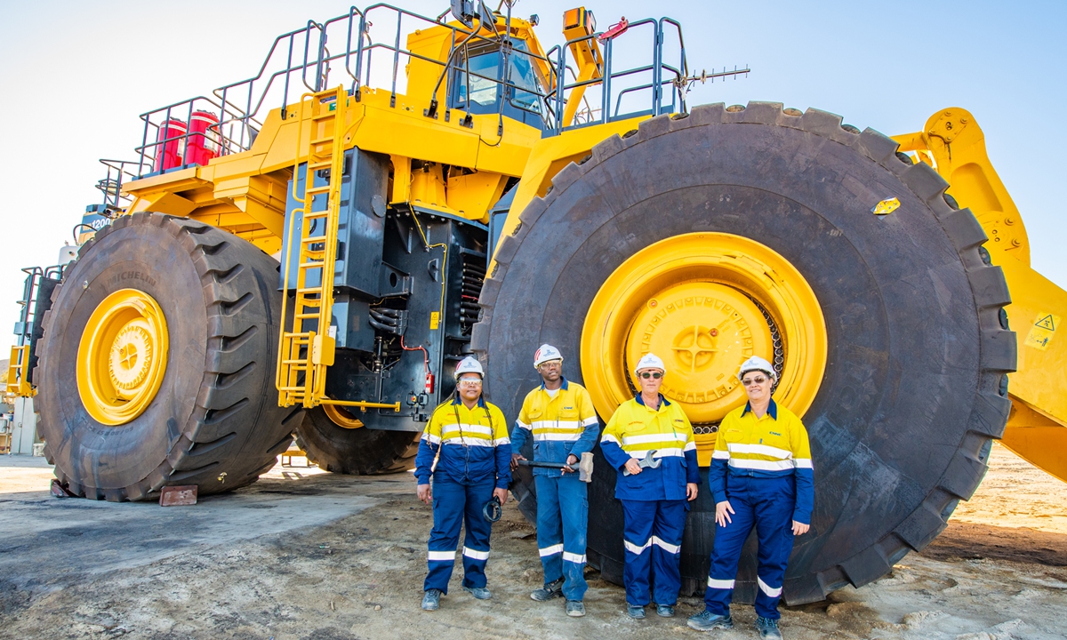 Namibian employees at Rossing Uranium Mine pose for a photo with a giant piece of mining equipment. Photo: Courtesy of CNNC