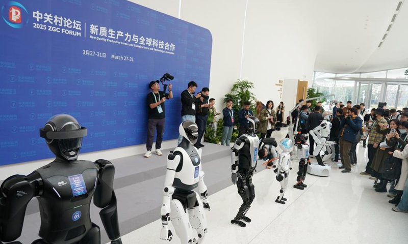 Journalists take photos of humanoid robots at Zhongguancun International Innovation Center, venue for the 2025 Zhongguancun Forum (ZGC Forum), in Beijing, capital of China, March 26, 2025.   (Xinhua/Zhang Chenlin)
