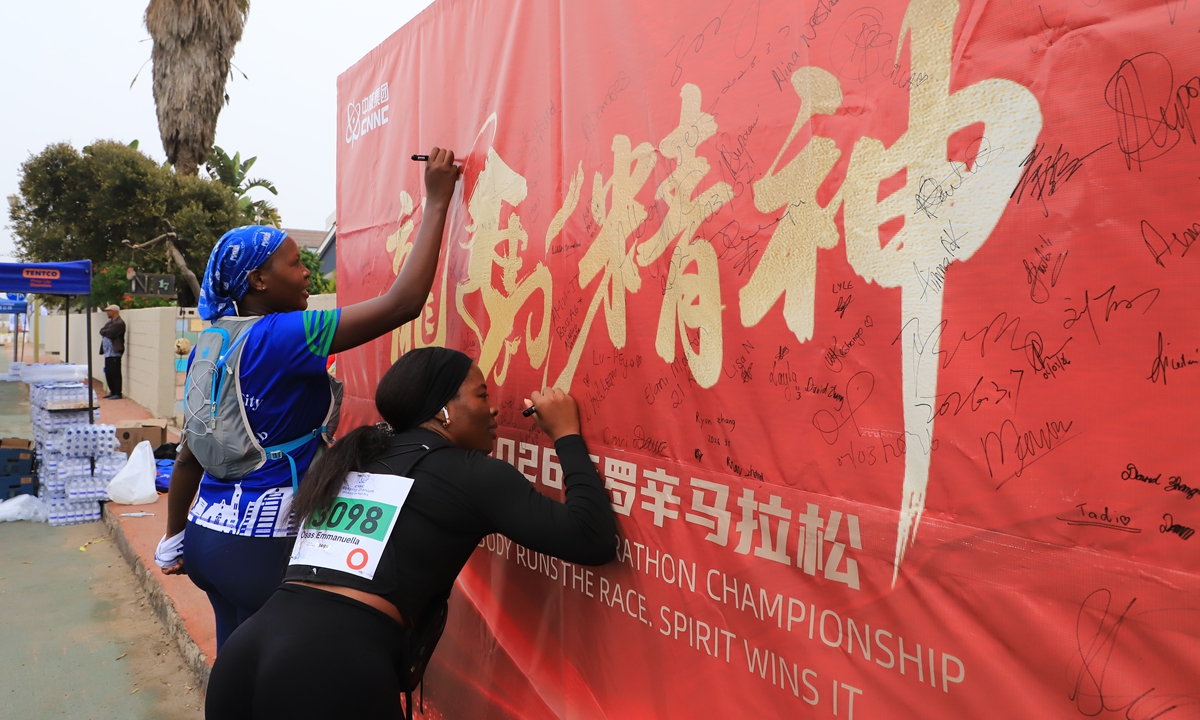 Participants in the 35th Rossing National Marathon Championship sign their names on a signature wall bearing the Chinese characters 
