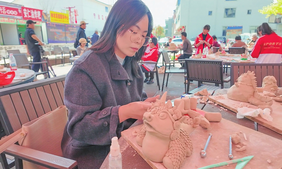 A woman takes part in an animal sculpture competition on March 19, 2026 ahead of the Ganfenshe Festival in Anren county, Central China's Hunan Province.