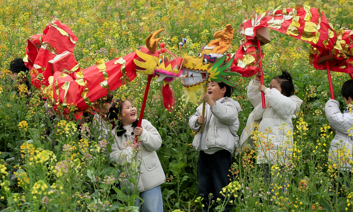 Children perform a dragon dance in a rapeseed flower field in Wenling, East China's Zhejiang Province, on March 19, 2026, to welcome the day of Longtaitou on March 20, which literally means 