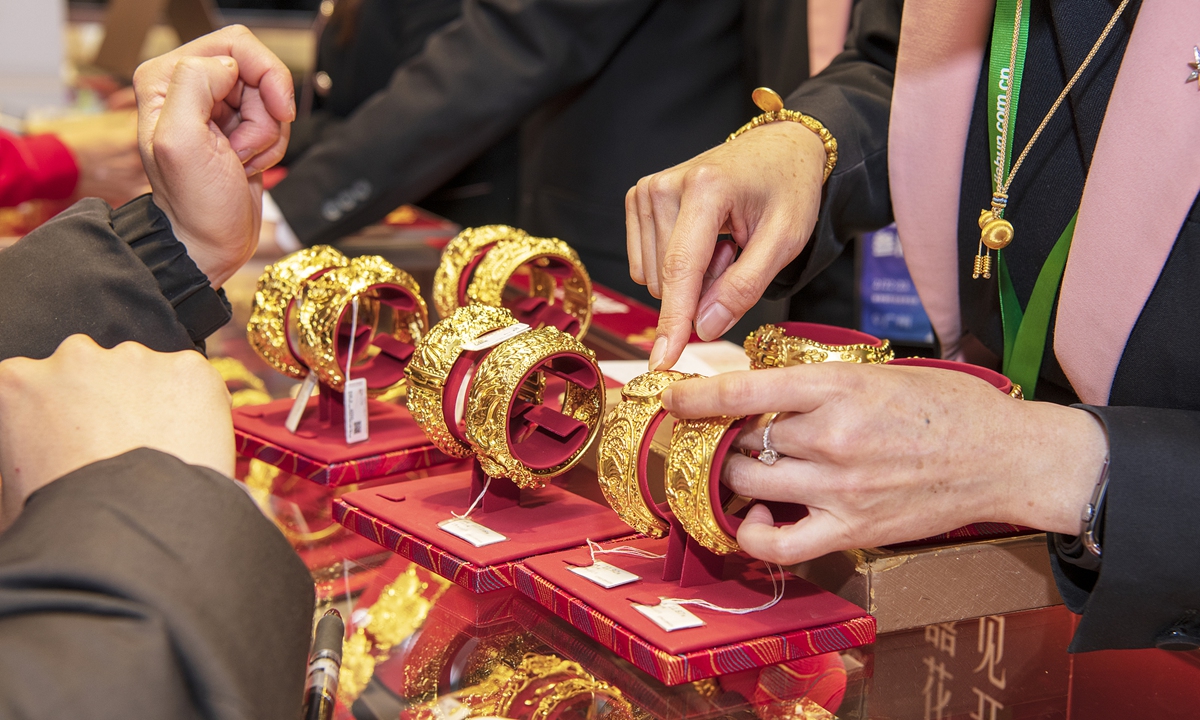 A sales representative shows a piece of gold jewelry at an expo in Guangzhou, South China's Guangdong Province. File photo: VCG