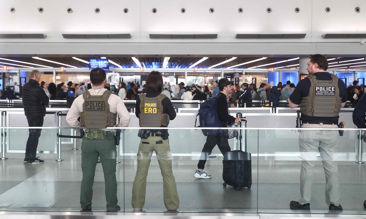 US Federal law enforcement agents stand watch as travelers arrive at a security checkpoint in Terminal 4 at John F. Kennedy International Airport in New York, US, on March 23, 2026. Immigration agents will be deployed in US airports beginning Monday, aiming to alleviate soaring congestion at security screenings amid a weeks-long budget standoff over US President Donald Trump's mass deportation drive, officials said, AFP reported. Photo: VCG