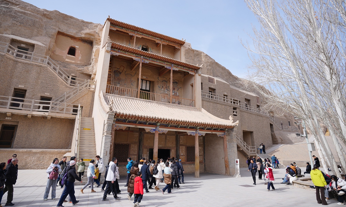 Tourists walk outside of the Library Cave of the Mogao Caves in Dunhuang, Northwest China's Gansu Province on February 22, 2026. Photo: VCG
