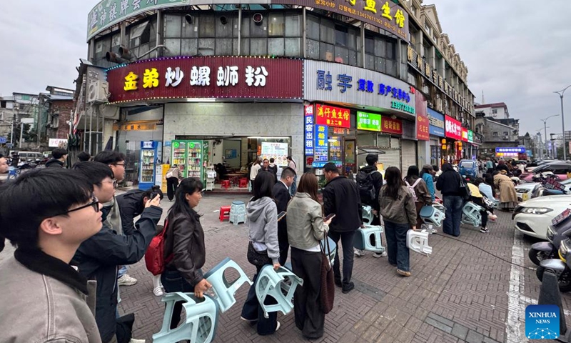 People queue up to buy stir-fried Luosifen from a shop in Liuzhou City, south China's Guangxi Zhuang Autonomous Region, March 10, 2026.(Photo by Zheng Changhao/Xinhua)