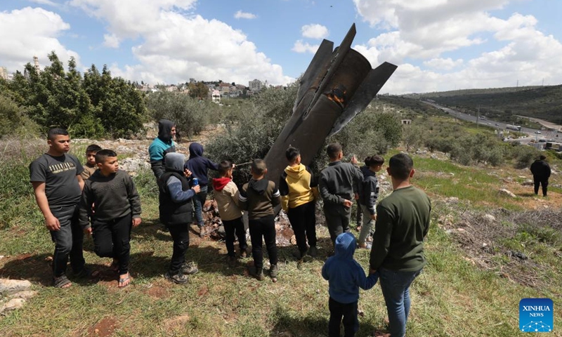 Palestinians inspect the wreckage of a missile which fell in the town of Haris, north of Salfit in the West Bank, on March 24, 2026. (Photo by Nidal Eshtayeh/Xinhua)

