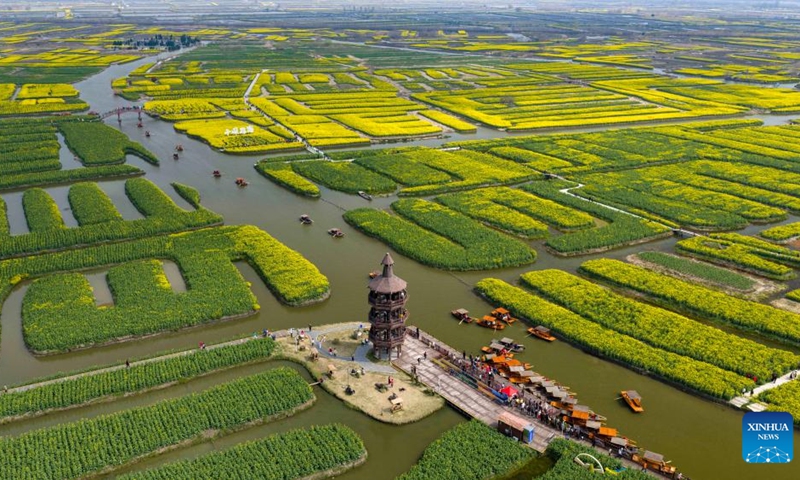 A drone photo taken on March 23, 2026 shows tourists visiting a scenic area in Xinghua City, east China's Jiangsu Province. (Photo by Zhou Shegen/Xinhua)

