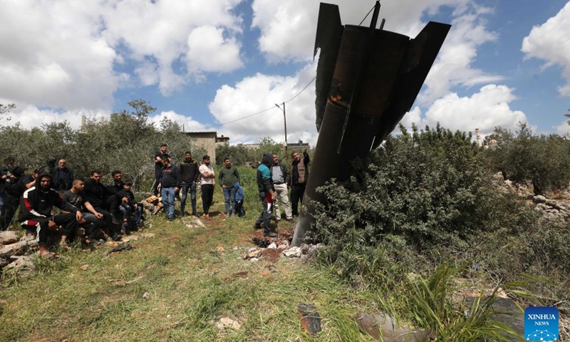 Palestinians inspect the wreckage of a missile which fell in the town of Haris, north of Salfit in the West Bank, on March 24, 2026. (Photo by Nidal Eshtayeh/Xinhua)


