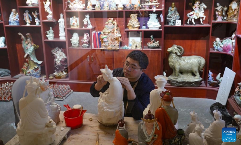 Zeng Rui works on a porcelain sculpture at his studio in Jingdezhen, east China's Jiangxi Province, March 12, 2026.(Xinhua/Zhou Mi)

