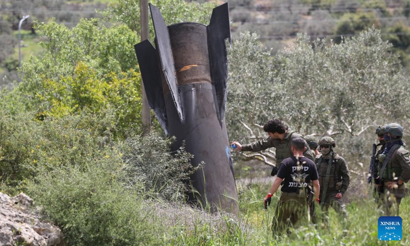Israeli soldiers stand guard near the wreckage of a missile which fell in the town of Haris, north of Salfit in the West Bank, on March 24, 2026. (Photo by Nidal Eshtayeh/Xinhua)


