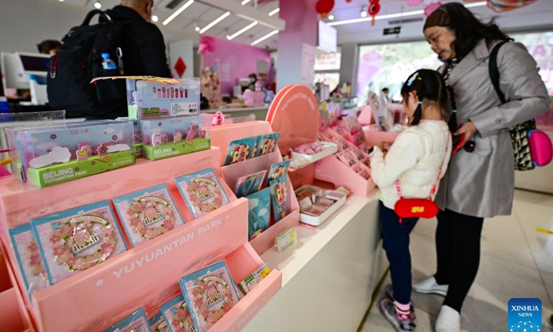 People look at cultural and creative products in a shop at Yuyuantan Park in Beijing, capital of China, March 23, 2026. As temperature rises, multiple parks and scenic spots in Beijing have held spring-themed fairs and launched cultural and creative products, giving a nice boost to the spring economy. (Xinhua/Chen Yehua)

