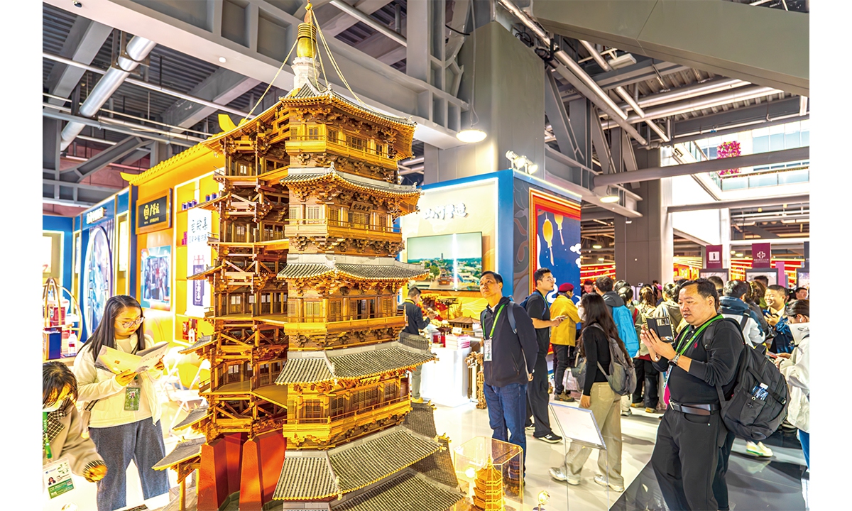 Visitors explore a replica of the Wooden Pagoda of Yingxian at the Shanxi pavilion during the 8th China International Import Expo in Shanghai on November 9, 2025.