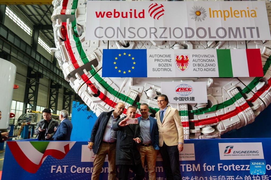Customer representatives take a selfie in front of the tunnel boring machine (TBM) to be exported to Italy at the second industrial park of China Railway Construction Heavy Industry Corporation Limited in Changsha, central China's Hunan Province, March 26, 2026. (Xinhua/Chen Sihan)