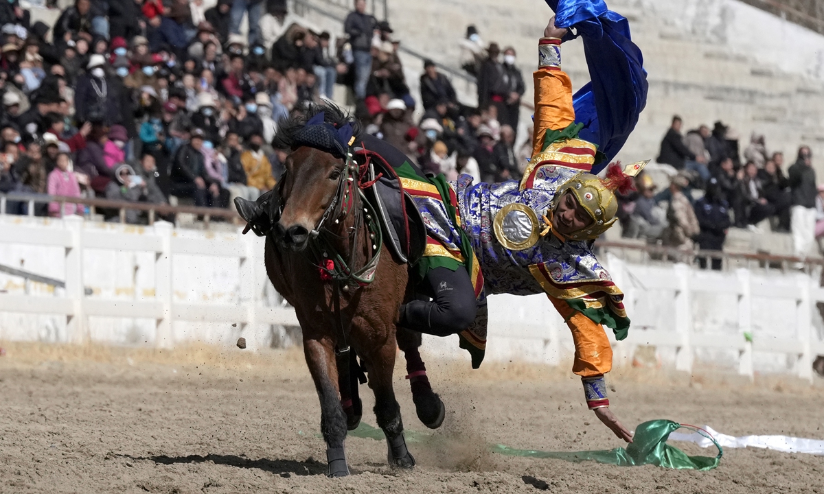 A rider performs during a traditional equestrian show and horse-racing event celebrating the third day of the Tibetan New Year at a horse racing track in Lhasa, Xizang Autonomous Region, on March 2, 2026.