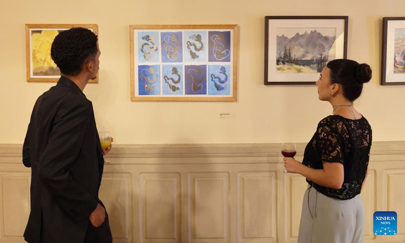 Visitors watch Brazilian paintings at a Chinese-Brazilian calligraphy and painting exhibition at the Municipal Theatre of Rio de Janeiro in Brazil, March 25, 2026. The exhibition, themed on Horizons in Dialogue, kicked off in Rio de Janeiro on Wednesday. (Xinhua/Jin Haoyuan)