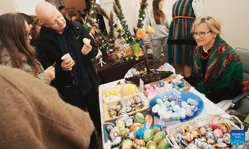 People look at traditional Easter eggs at an Easter fair in Warsaw, Poland, March 28, 2026. Various Polish handicrafts and cultural activities were presented at the event held by the Polish National Institute of Culture and Rural Heritage in Warsaw. (Photo by Jaap Arriens/Xinhua)